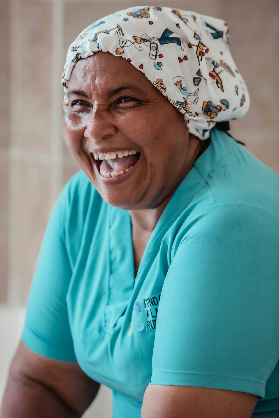 A caregiver in scrubs laughing